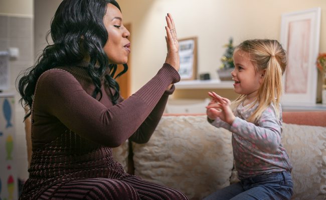 African American woman playing with girl.